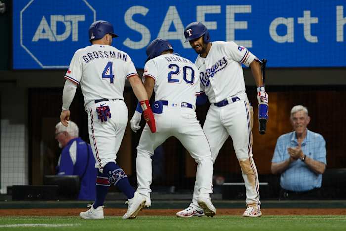 Texas Rangers left fielder Ezequiel Duran (20) is congratulated by designated hitter Robbie Grossman, left, and second baseman Marcus Semien, right, after hitting a two-run home run in the sixth inning Monday night against the Tampa Bay Rays at Globe Life Field.